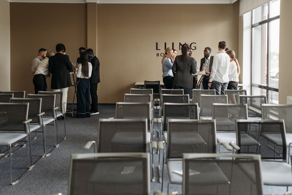 A group discussion taking place in a contemporary conference room with empty chairs.